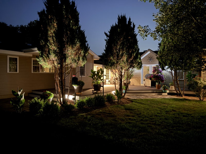 Evening view of lighted covered deck and outdoor seating area