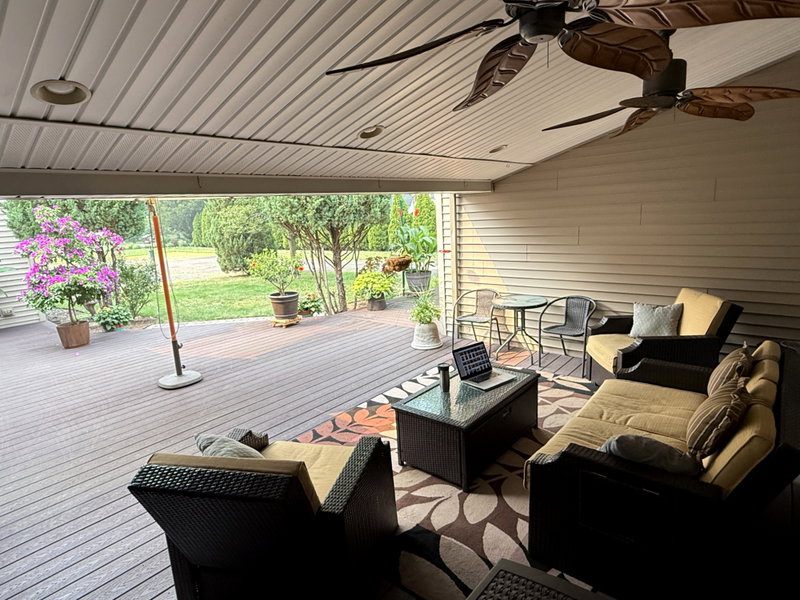 Comfortable covered deck seating area with backyard views